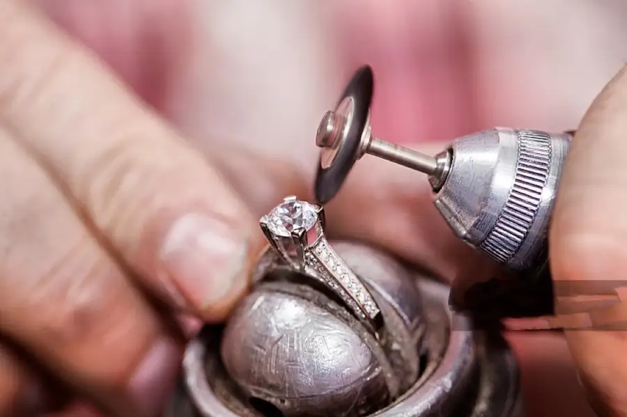 Jewelry artisan setting and refining a custom piece